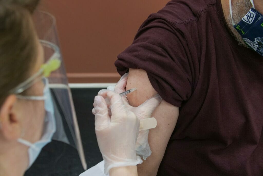 Imagen muestra a personal de salud inyectando la vacuna contra el coronavirus a otra persona - 