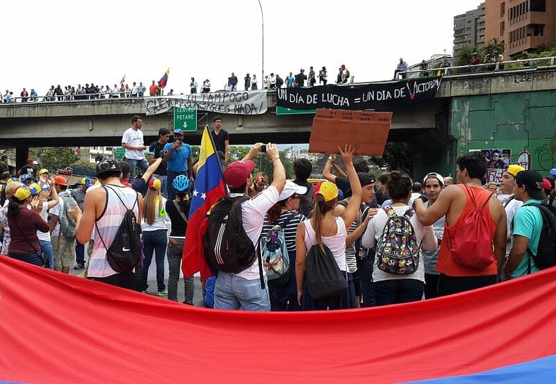 La nota informa sobre la situación de los venezolanos en Estados Unidos. La foto es de manifestaciones por aspectos económicos y políticos.