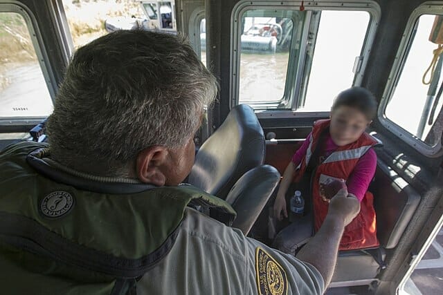 La nota es sobre la nueva propuesta de la administración Biden para reformar el sistema de asilo. La foto es de una niña encontrada en la frontera junto a un agente de la Patrulla Fronteriza. 