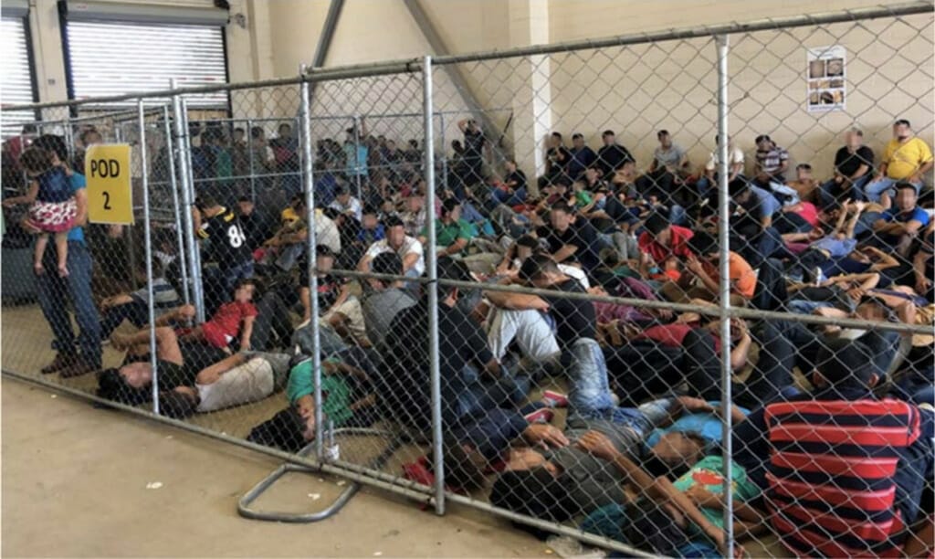 Este artículo habla sobre el acuerdo legal conseguido por personas detenidas en los centros de detención de inmigración. La imagen muestra un grupo de personas hacinadas en un centro.