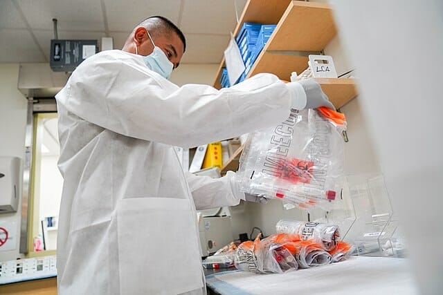 Este artículo habla sobre el fin de Título 42.  La imagen muestra a un trabajador de la salud preparando kits para testear Covid-19.
