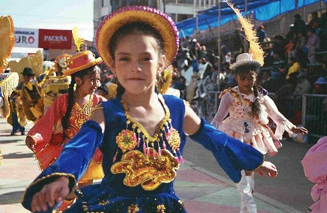 Este artículo habla sobre el Carnaval en Latinoamérica. La imagen muestra niñas con trajes típicos del carnaval de Oruro..