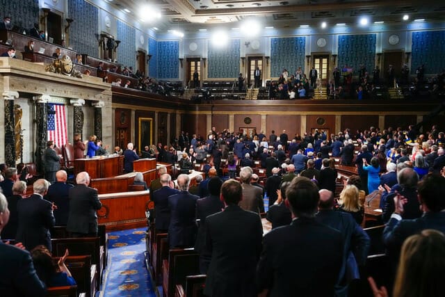 Este artículo habla sobre el discurso State of the Union 2022. La imagen muestra el momento en que los asistentes del discurso muestran su apoyo al pueblo ucraniano después de que el presidente Biden mencionara la situación en aquél país.