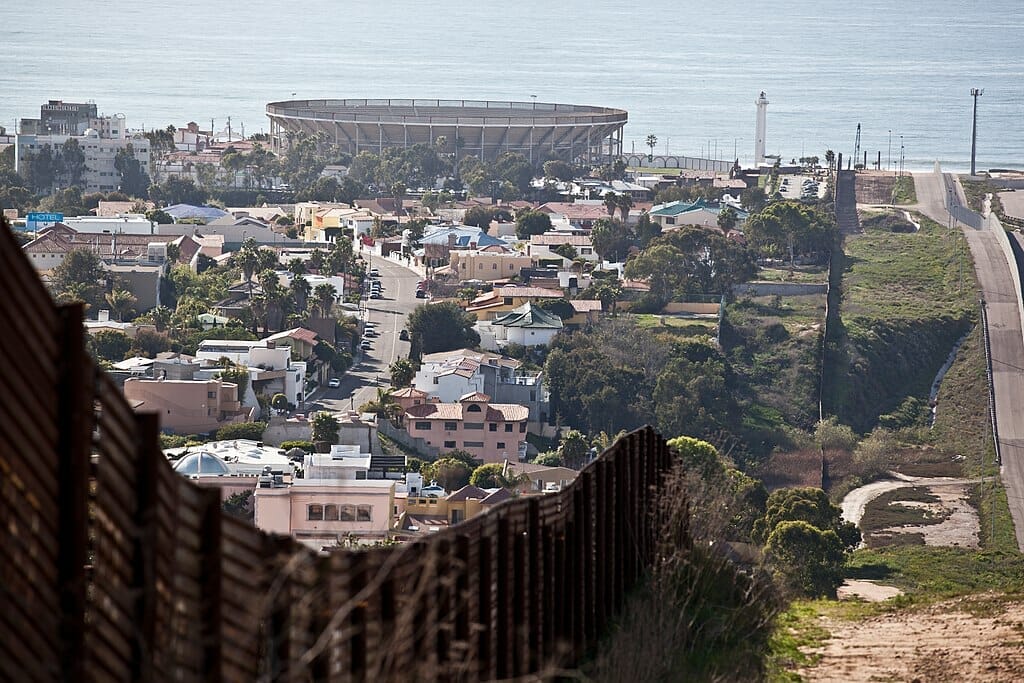 Este artículo habla sobre el campamento de migrantes en Tijuana que fue desmantelado. La imagen muestra la frontera entre Estados Unidos y Tijuana.