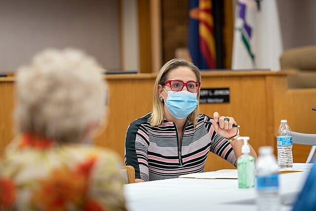 Este artículo habla sobre la política título 42 y el posible voto del Senado. La imagen muestra a la senadora Kyrsten Sinema en una reunión durante la pandemia utilizando mascarilla.