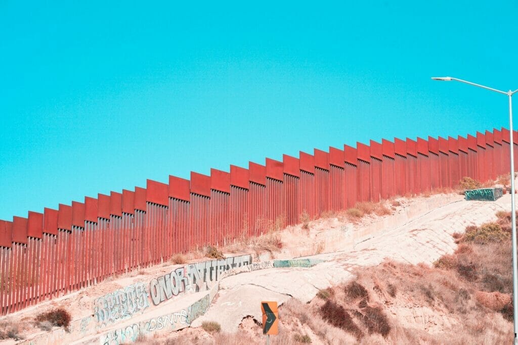 Este artículo habla sobre el plan de la administración Biden para lidiar con los altos números de cruces de frontera. La imagen muestra el muro fronterizo entre México y Estados Unidos.