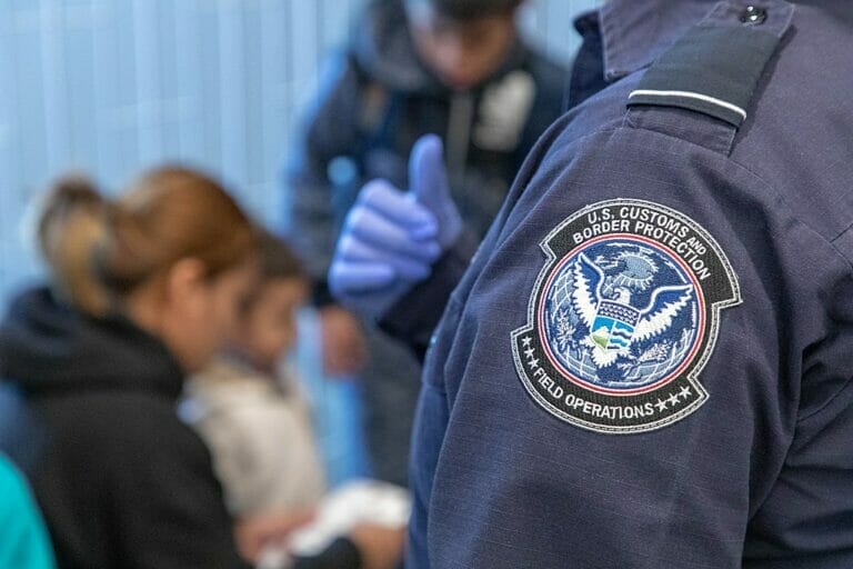 Oficial fronterizo procesa a inmigrantes solicitando asilo.