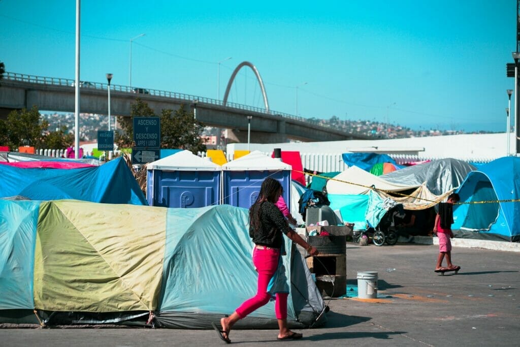 Este artículo habla sobre Quédate en México y el veredicto de la Corte Suprema. La imagen muestra un campamento de migrantes del lado mexicano de la frontera.