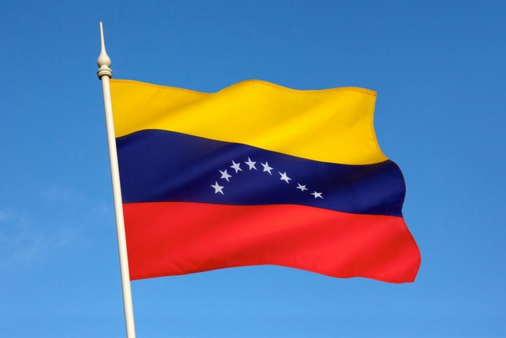 Bandera de Venezuela ondeando sobre el cielo azul.