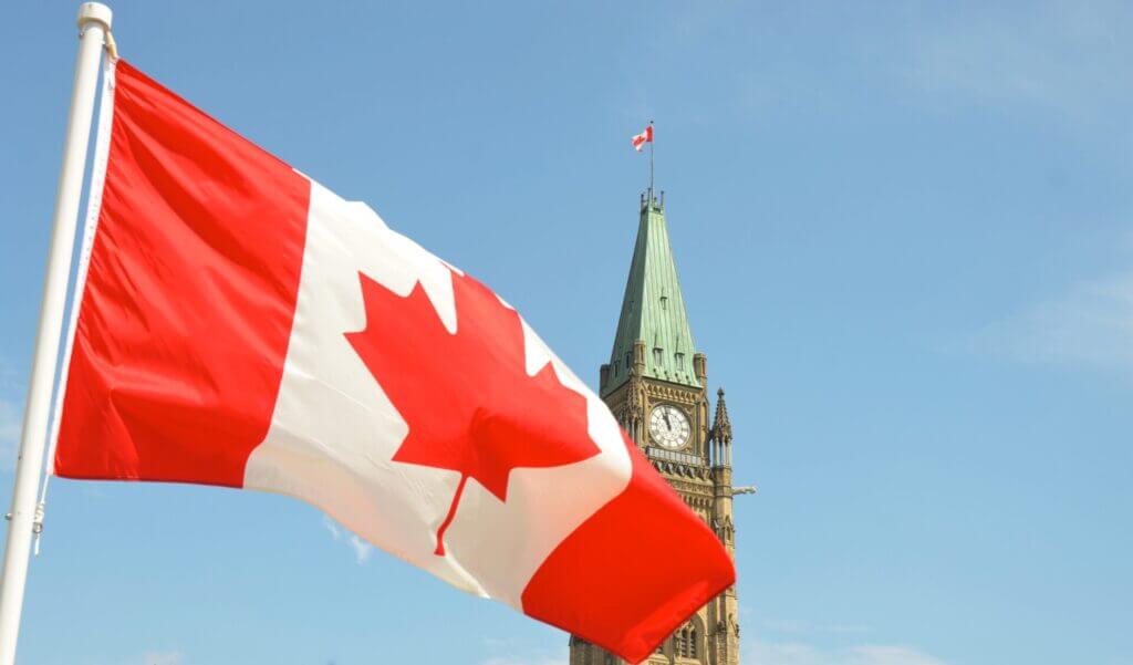 Bandera de Canadá sobre el cielo azul. Este artículo habla sobre emigrar a Canadá.