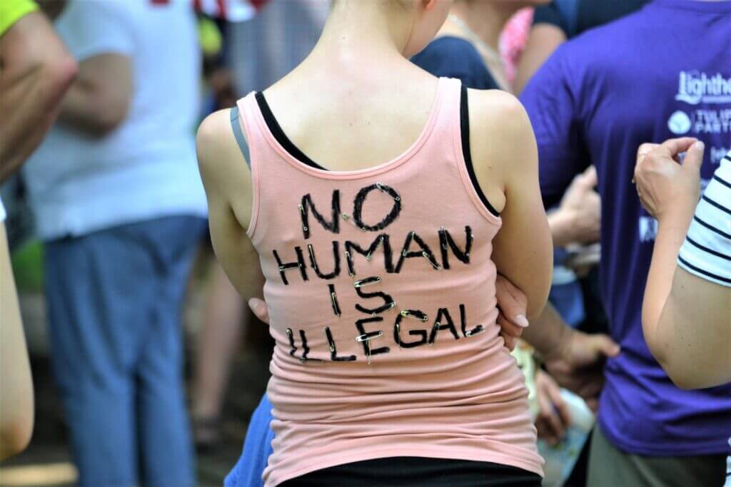 Joven con remera No Human is Illegal. Nota sobre tps extension 2022