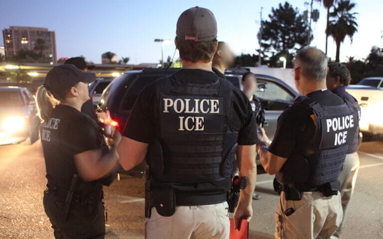 Tres oficiales de ICE vistos de espaldas. La agencia está bajo la mira tras ocurrir la brecha de datos de ICE, que expuso en línea daros confidenciales de solicitantes de asilo en custodia.