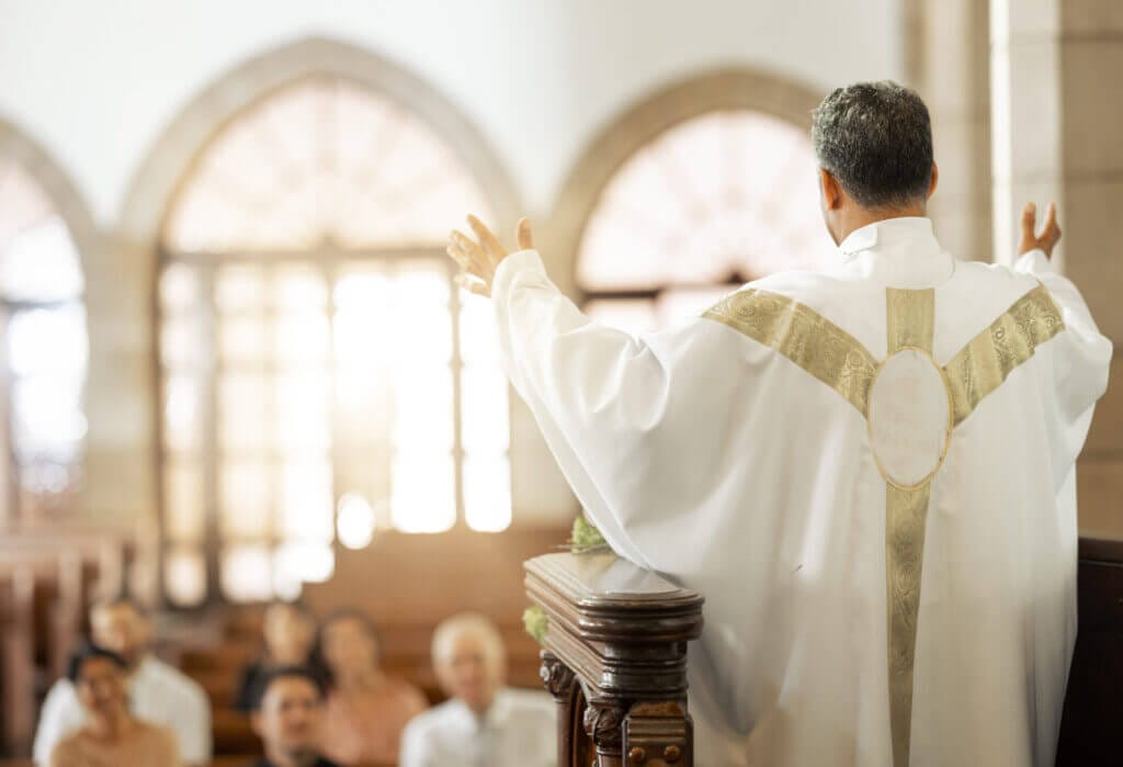 Obispo dando misa demostrando que la Iglesia ayuda a inmigrantes.