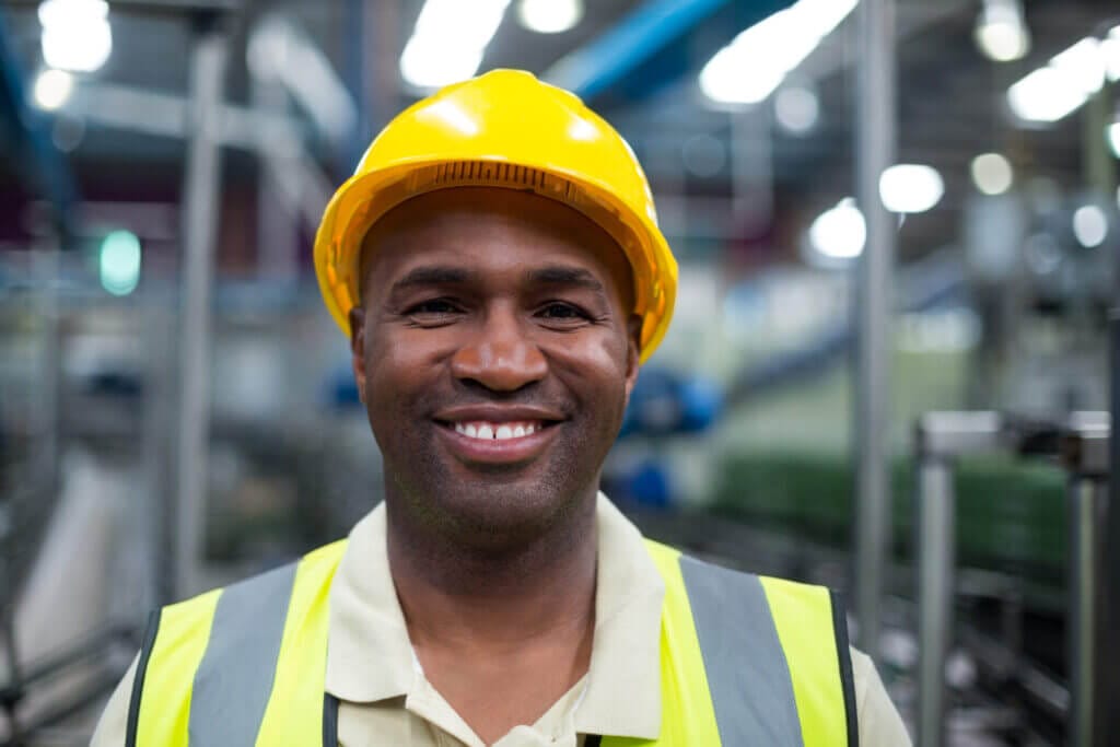 Trabajadores migrantes sonriendo a la cámara en su espacio laboral