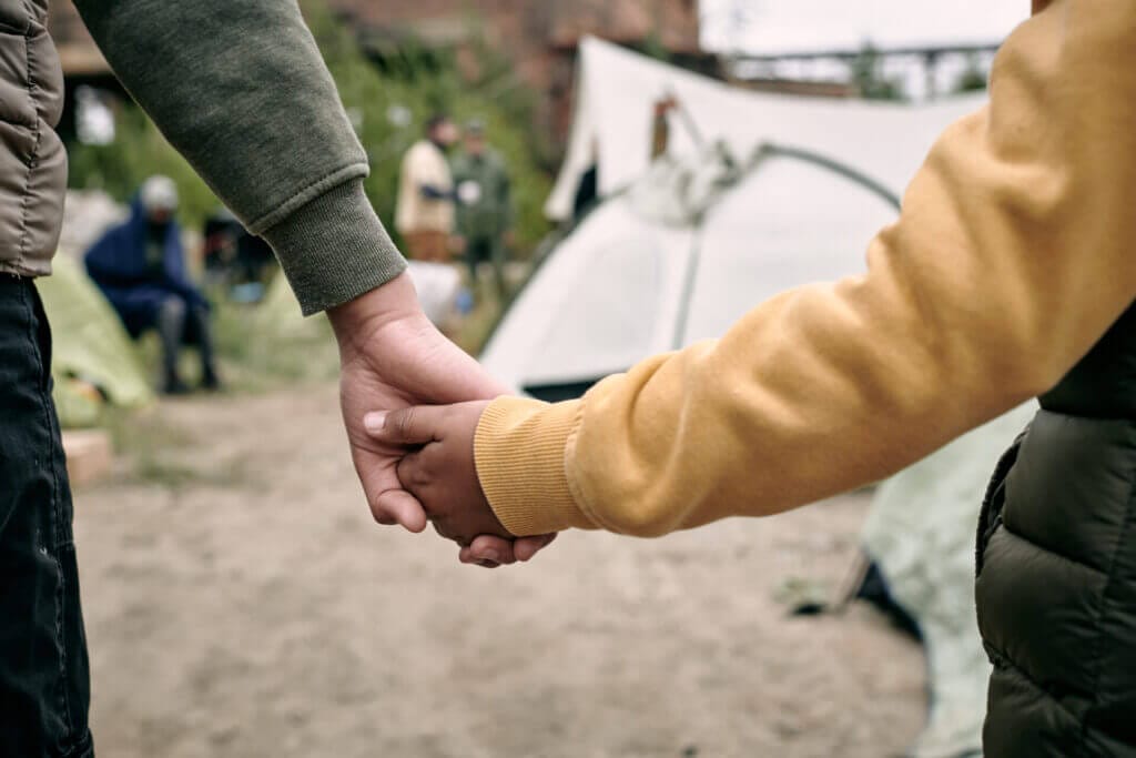 Dos menores migrantes tomándose la mano en la frontera de México