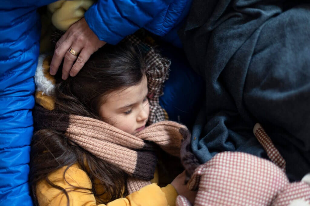 Niña migrante con su familia albergados en un centro de inmigración en Latinoamérica