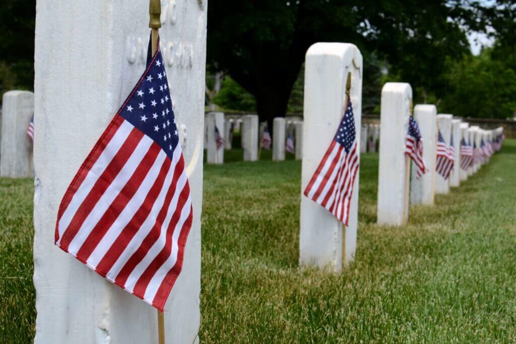 Filas de lápidas con banderas de Estados Unidos honrando a los caídos en el Memorial Day
