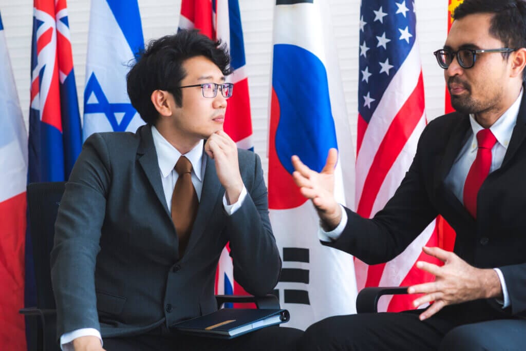 Dos diplomáticos migrantes conversando negocios internacionales en la embajada de EE.UU.