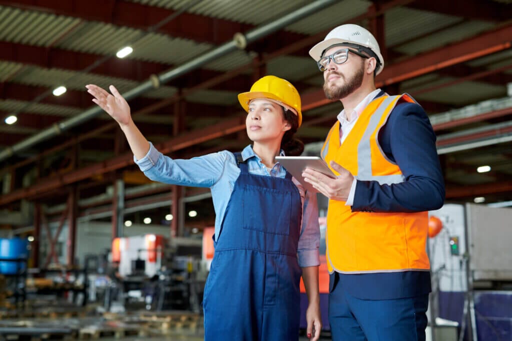 Dos obreros conversando en la fábrica tras obtener la visa h2a y h2b