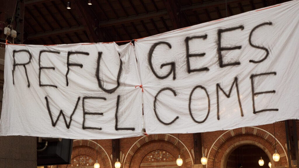 Pancarta de protesta que dice "Bienvenidos Refugiados" en señal de apoyo a los refugiados que llegan a Estados Unidos