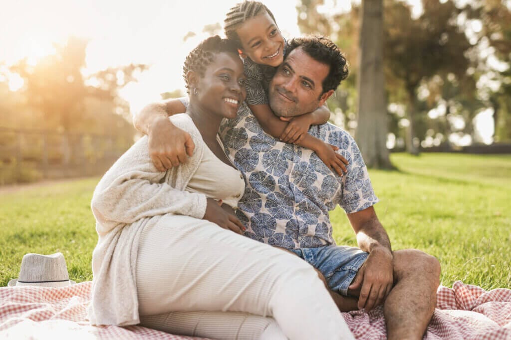 Familia de migrantes abrazadas disfrutando su compañía gracias a la visa familiar para Estados Unidos