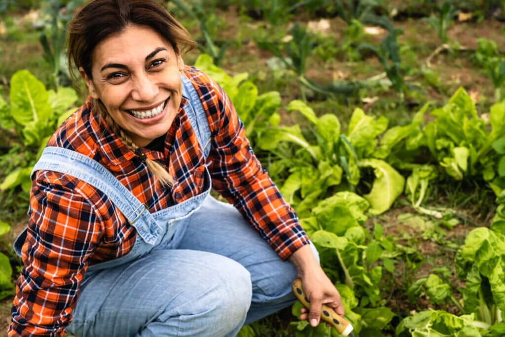 Empleada agrícola latina en Estados Unidos trabajando la tierra. 