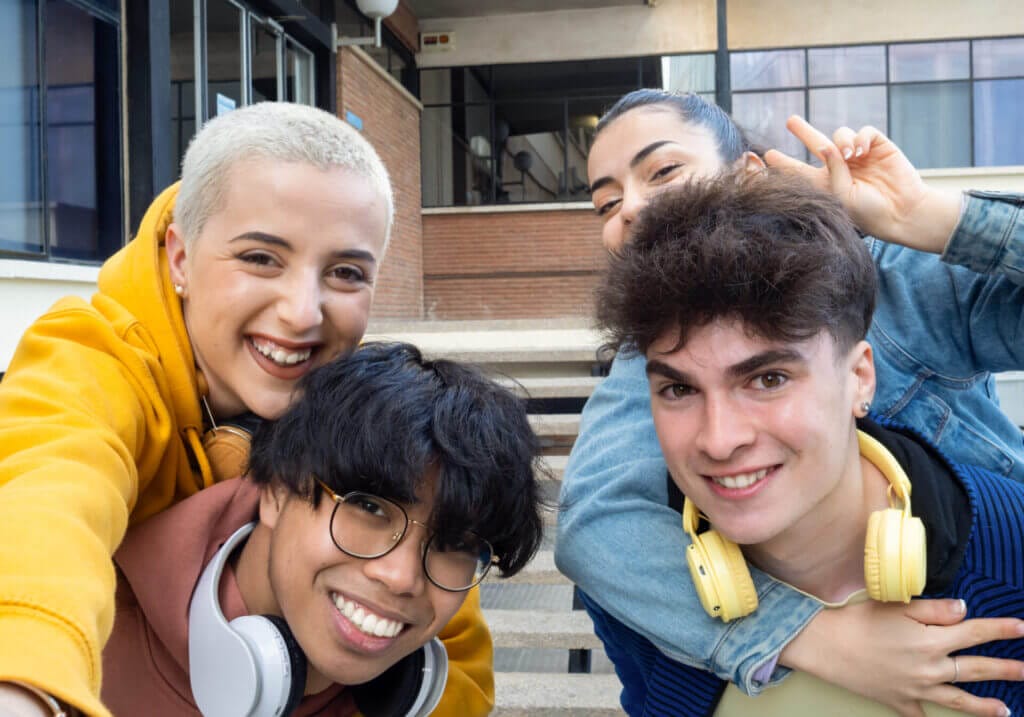 Grupo de jóvenes estudiantes sonriendo a la cámara