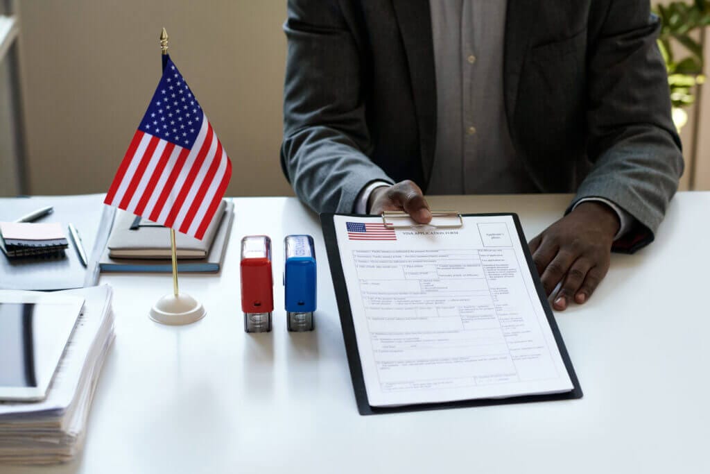 Oficial consular entregando documentos de renovación de visa a un aplicante