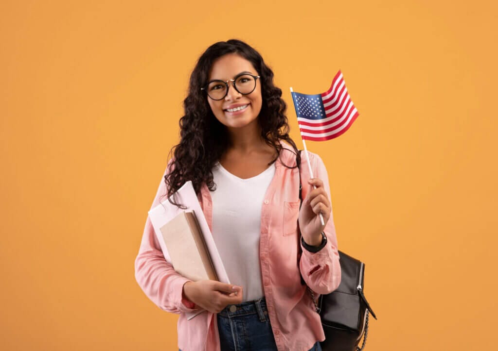 Estudiante extranjera estudiando en USA sonriendo a la camara con sus apuntes