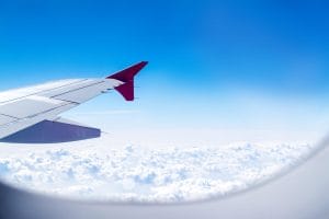 Ventana de un avión entre las nubes representando a la pregunta de si se puede viajar dentro de estados unidos sin papeles 2023