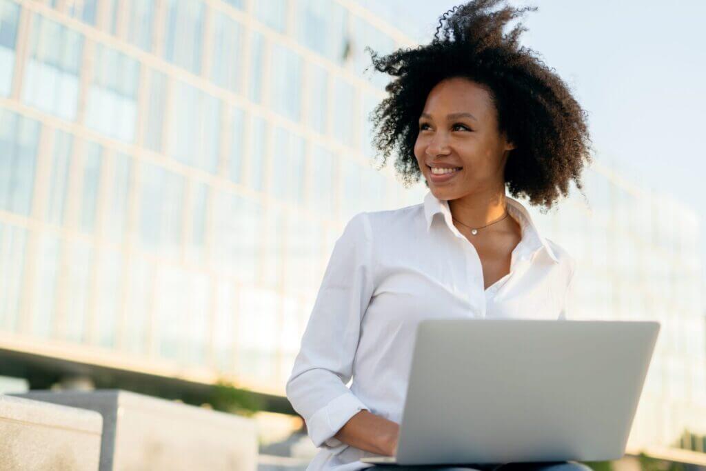 Mujer con su laptop sonriendo al aire libre