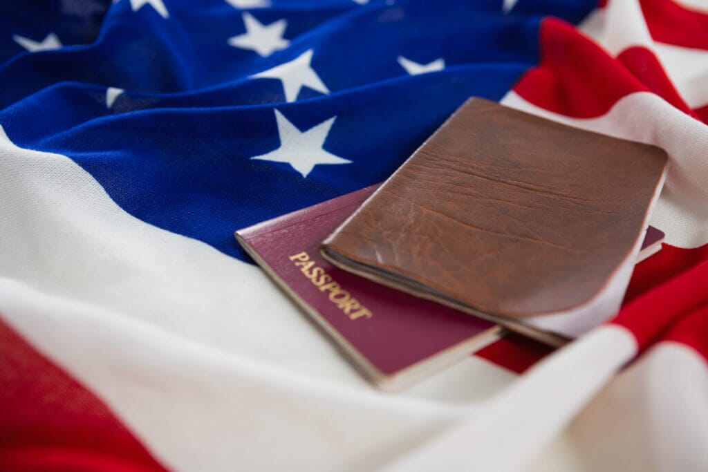 Imagen de cerca de un pasaporte y una visa sobre una bandera americana