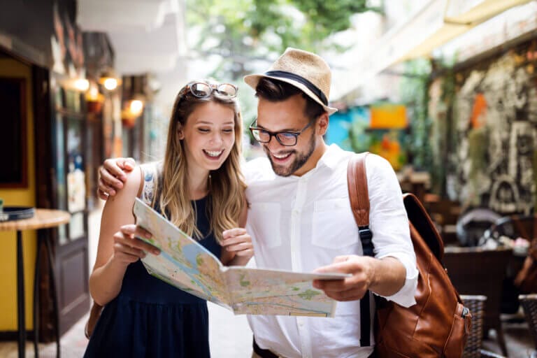Pareja de turistas mirando un mapa simbolizando el Día Mundial del Turismo
