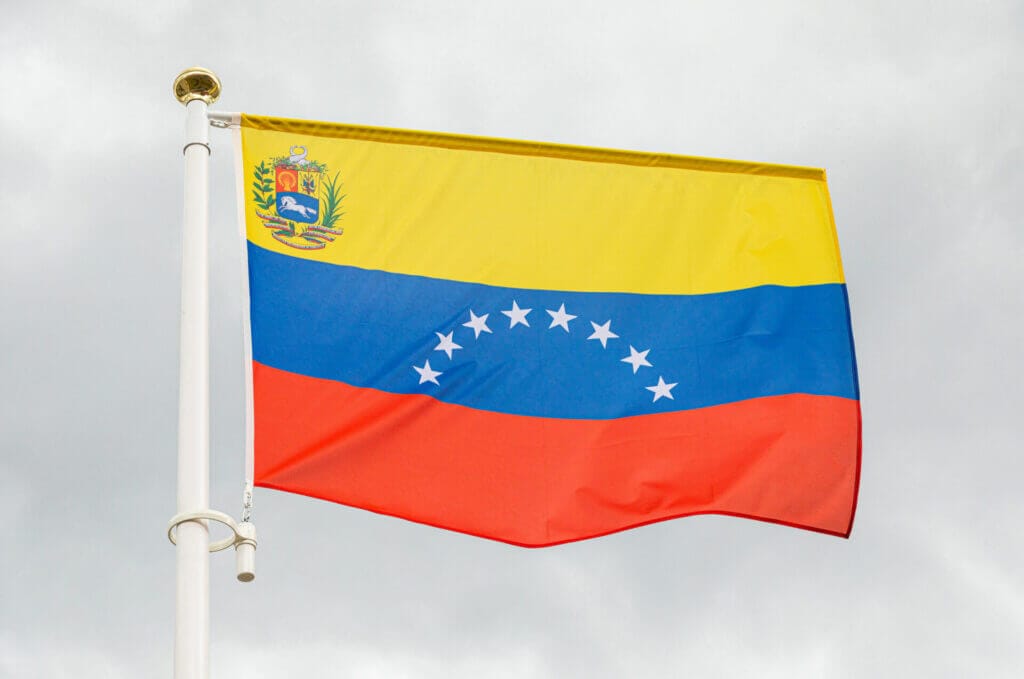 Bandera flameante de Venezuela en un cielo gris representando la deportacion de venezolanos en USA