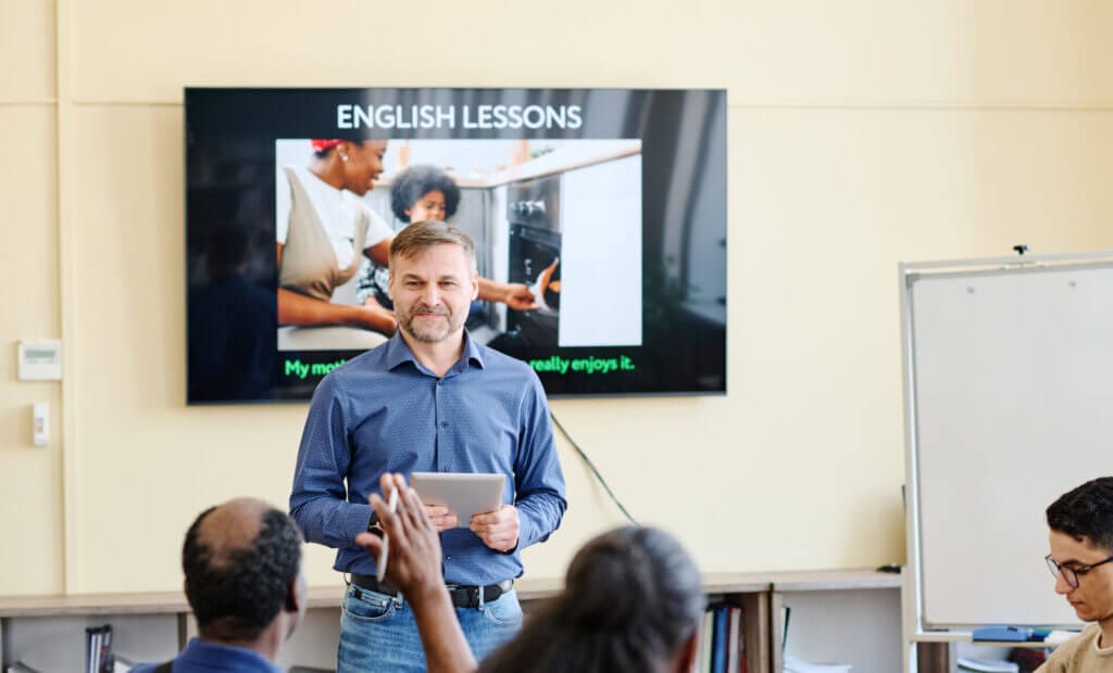 Profesor de inglés dando clases a un grupo de migrantes en USA