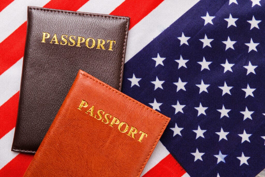 Dos pasaportes de viaje con una bandera estadounidense detrás