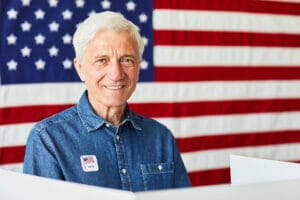 Imagen de ciudadano americano sonriendo con una bandera estadounidense detrás tras haber aprendido la gran diferencia entre residencia y ciudadanía