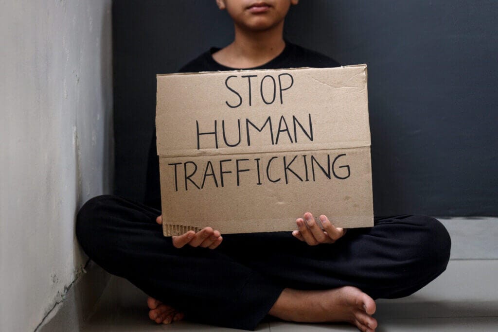 Mujer con un letrero que dice "Paren con el tráfico humano"