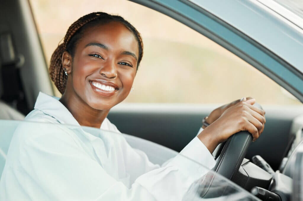 Retrato de una mujer sonriendo mientras maneja gracias a la licencia de conducir en Minnesota para indocumentados 2023