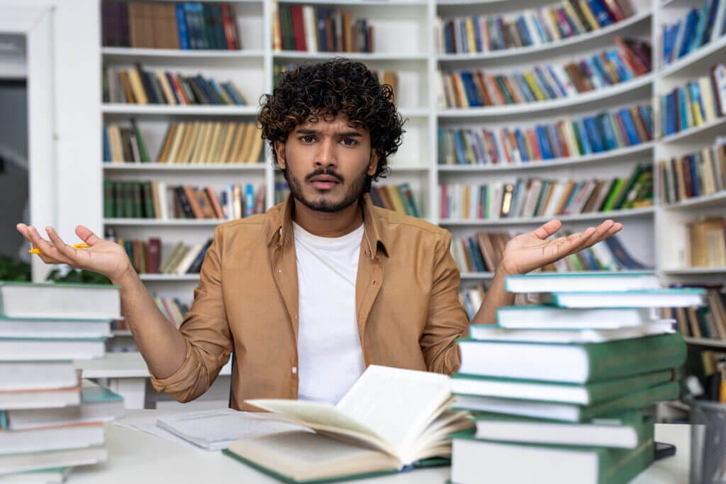 Estudiante frustrado en su escritorio sin saber porque niegan la visa de estudiante a estados unidos