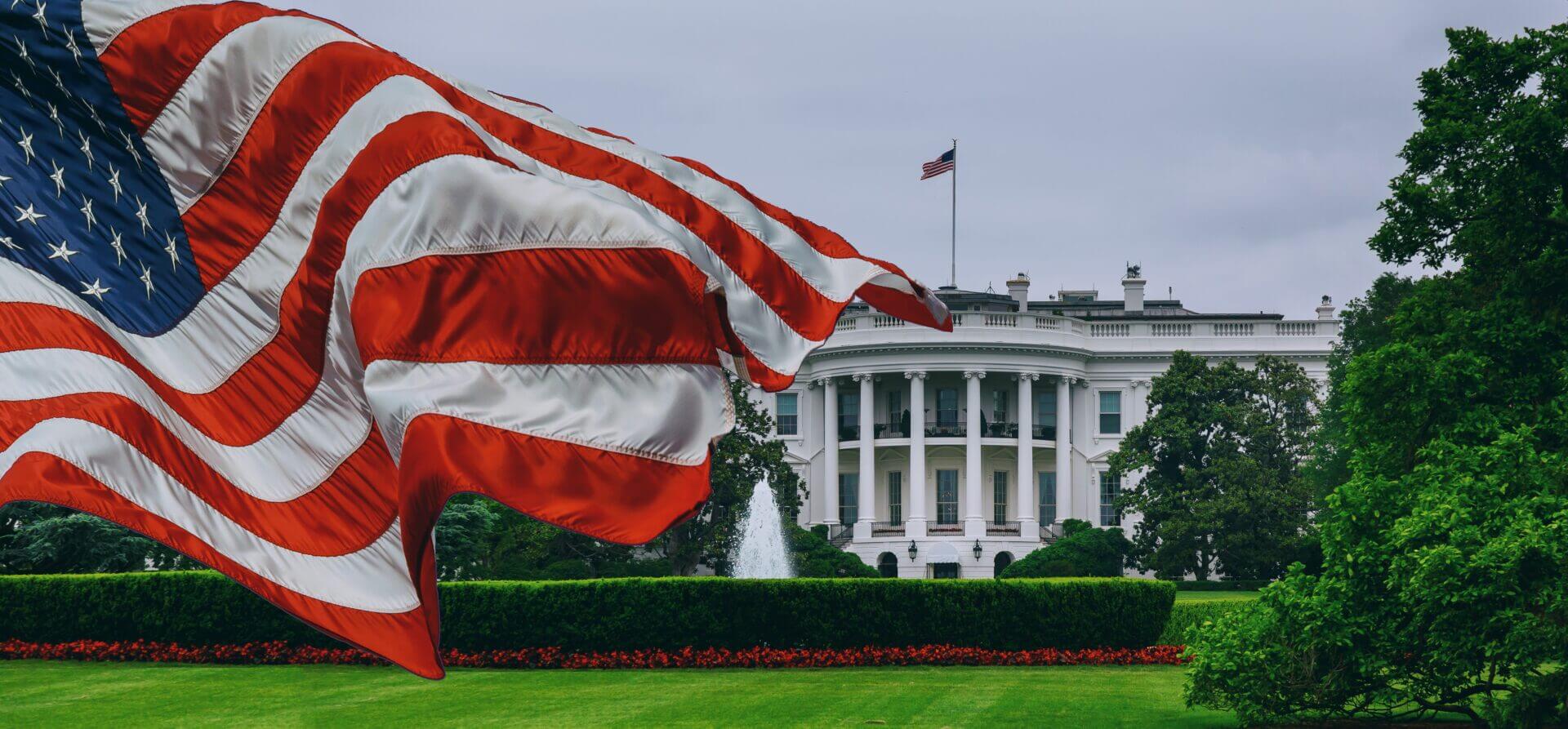 Casa Blanca con la bandera de USA flameando, representando la campaña Trump 2024
