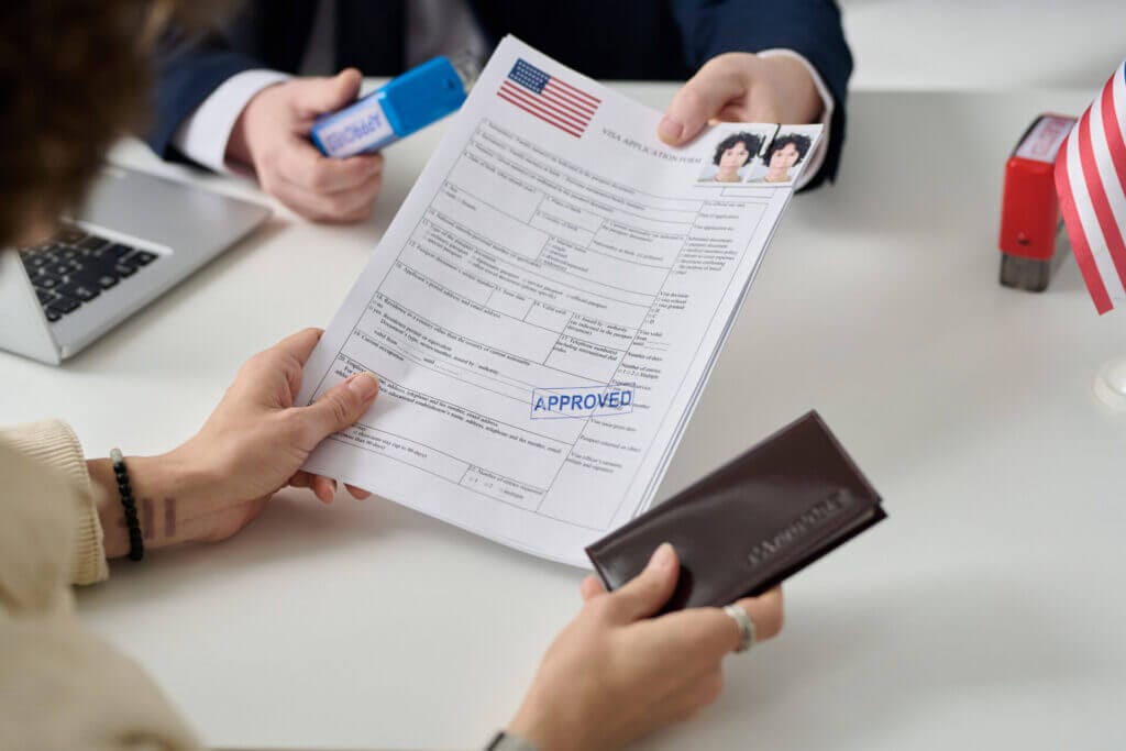 Mujer recibiendo su documentación migratoria para la visa en USA