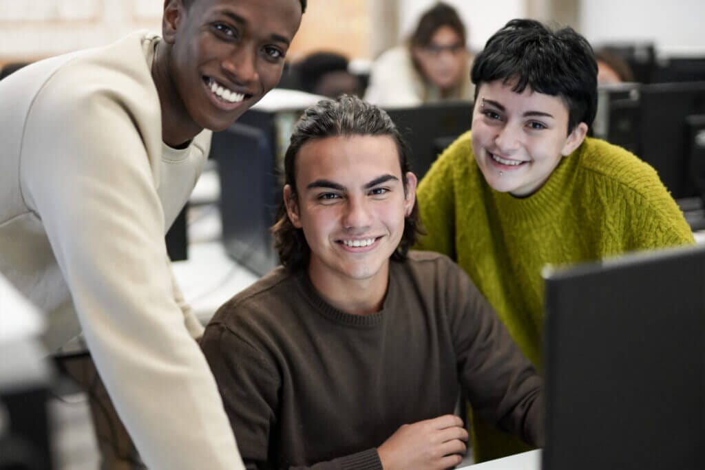 Estudiantes especializados en tecnología sonriendo mirando a la cámara