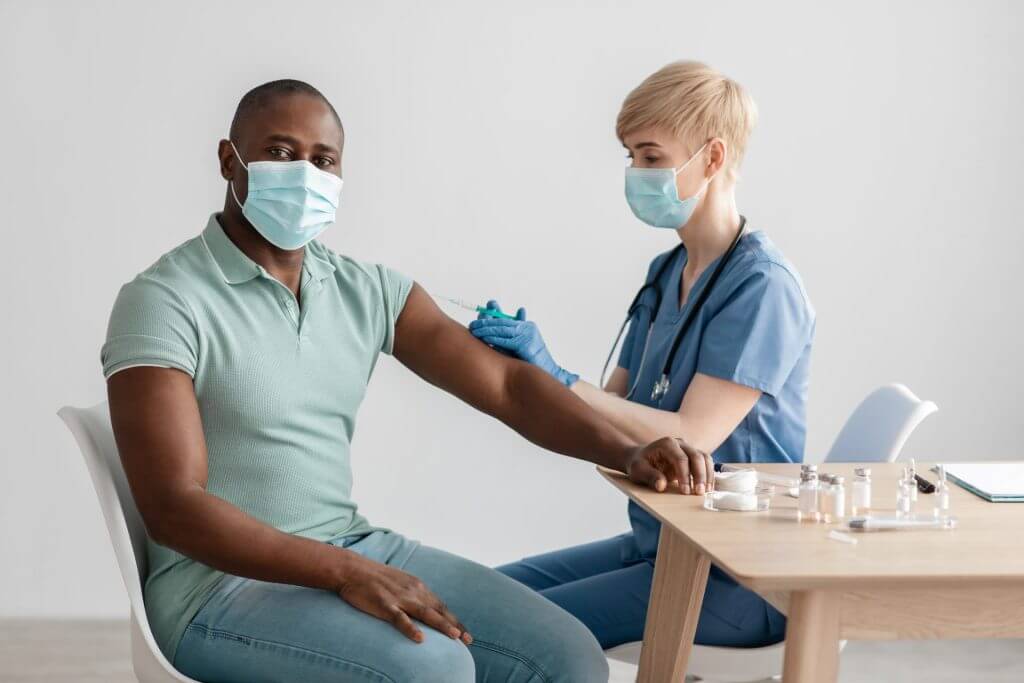 Hombre recibiendo vacunas gracias al seguro medico en estados unidos para inmigrantes