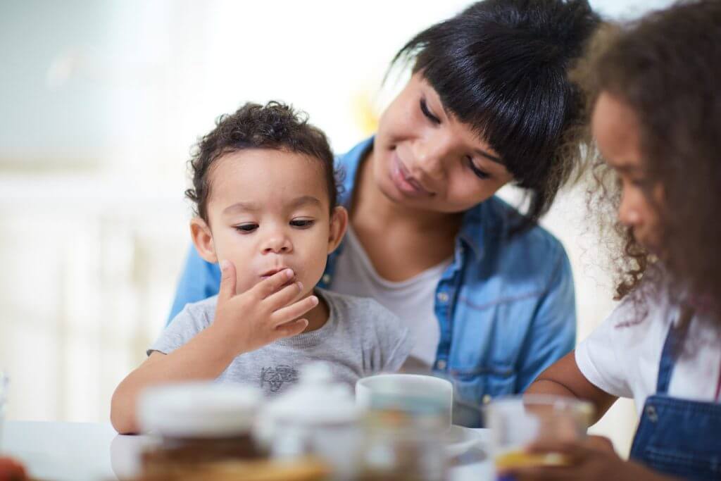 Madre dando de comer a sus dos hijos 