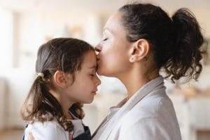 Madre besando agradecida a su hija tras aprender carga publica ejemplos