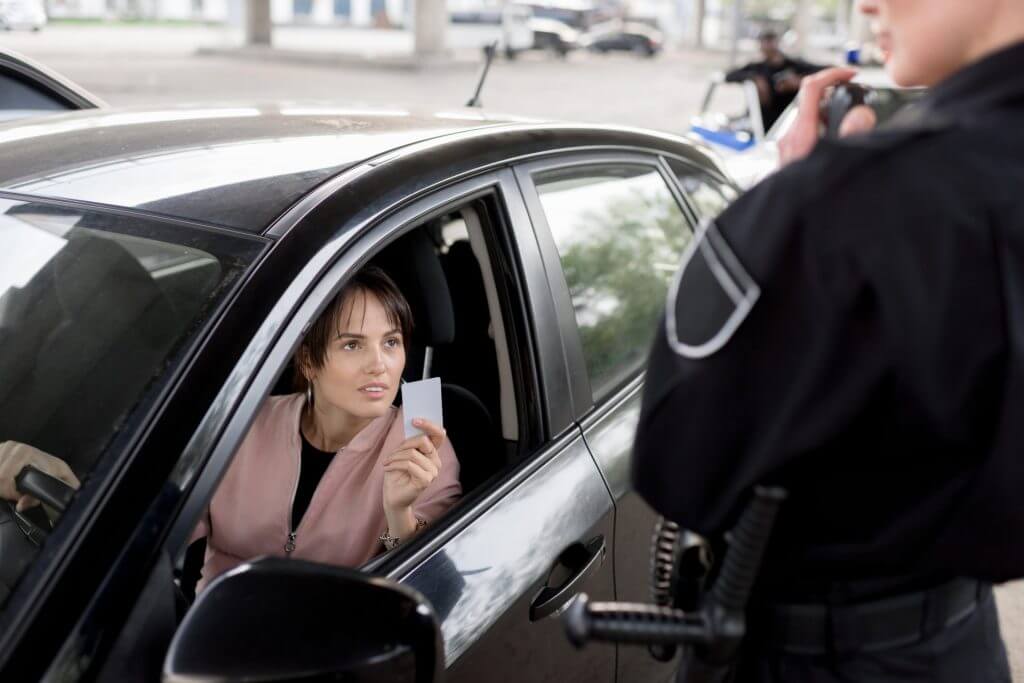 Mujer policía parando a una conductora que le muestra la licencia