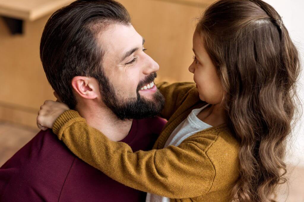 Padre e hija abrazados luego de la separación de familias migrantes