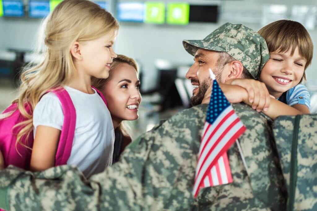 Militar estadounidense reuniéndose en un abrazo con sus hijos en el aeropuerto