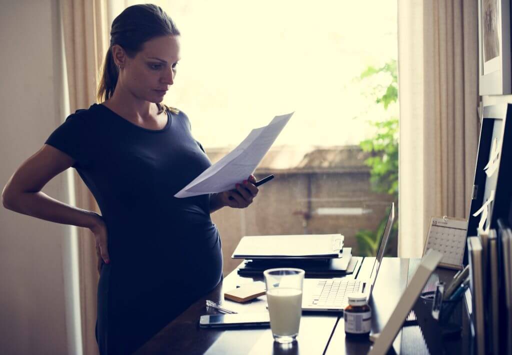 Mujer embarazada revisando documentos médicos